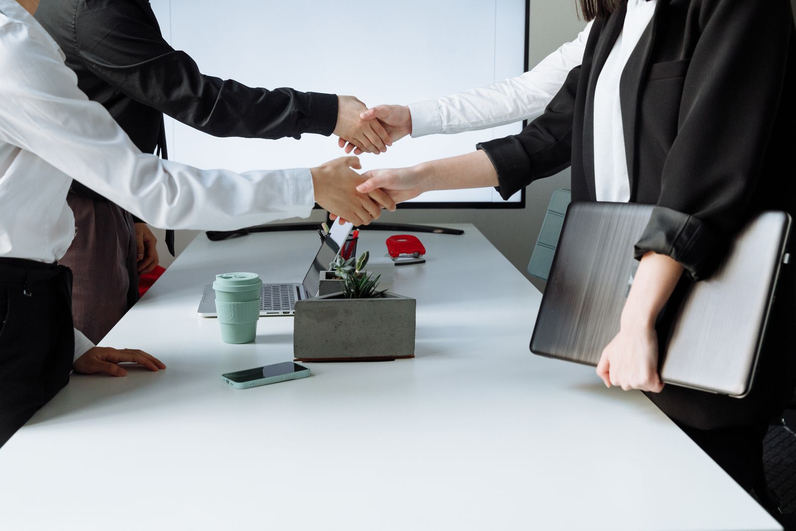 Poignée de main entre professionnels autour d une table de réunion